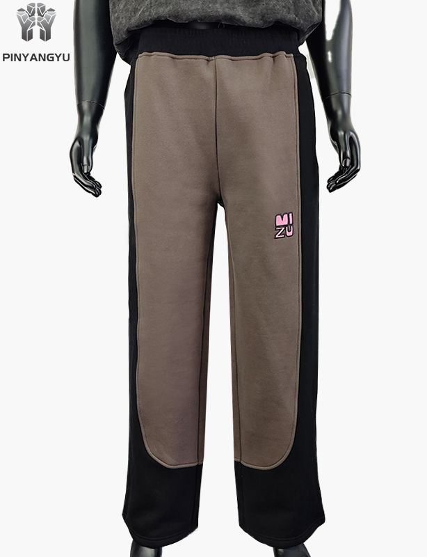 Calça de moletom estilo tecido emendado com design bordado