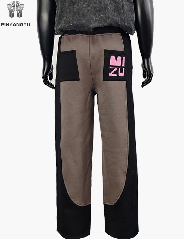 Calça de moletom estilo tecido emendado com design bordado
